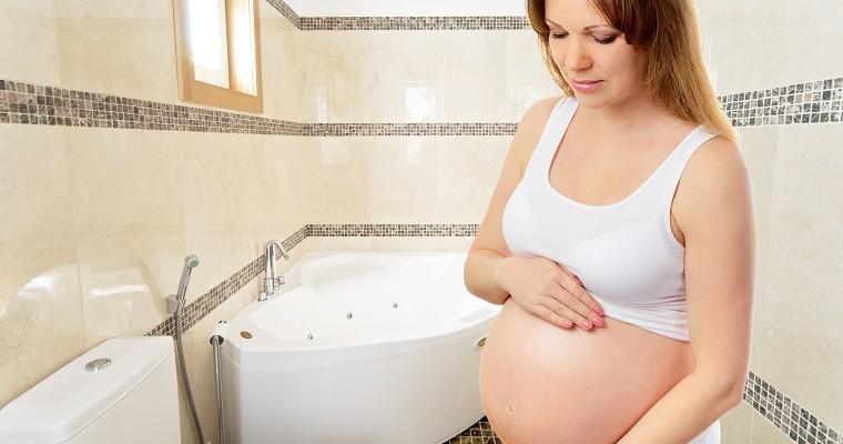 Kobieta w ciąży stoi w toalecie