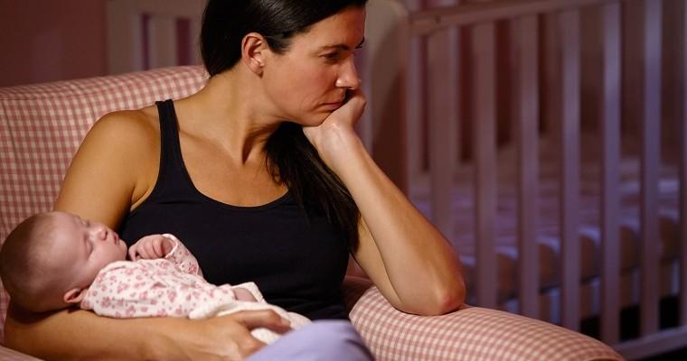 Kobieta trzymające niemowlę patrz smutno w bok