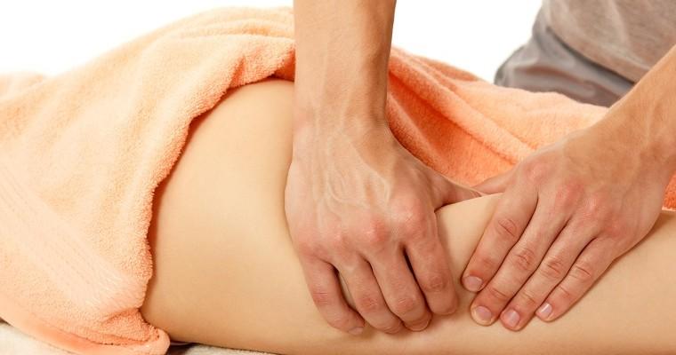  masażysta robi masaż pośladków młodej kobiecie