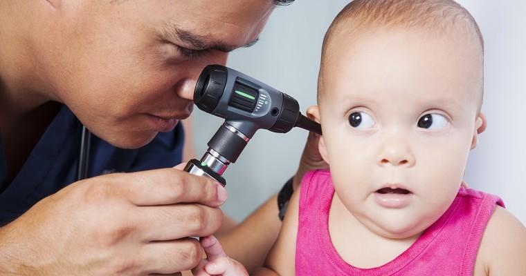  lekarz wykonuje badanie słuchu u dziecka.