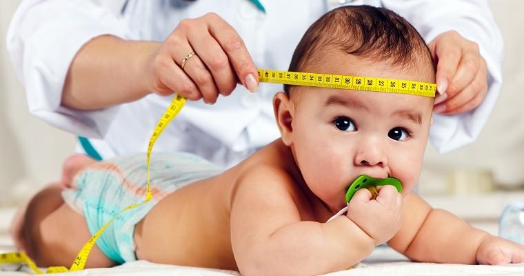  Pediatra mierzy głowę dziecka