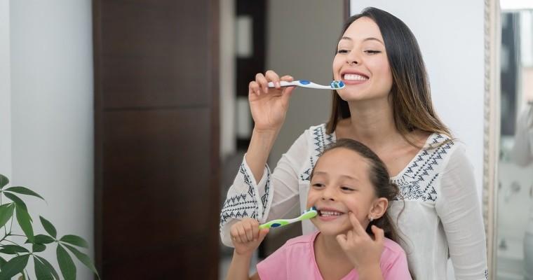 Matka i córka w domu szczotkują  zęby
