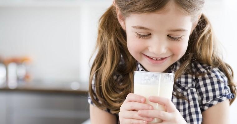 Dziewczyna patrząca na szklankę mleka