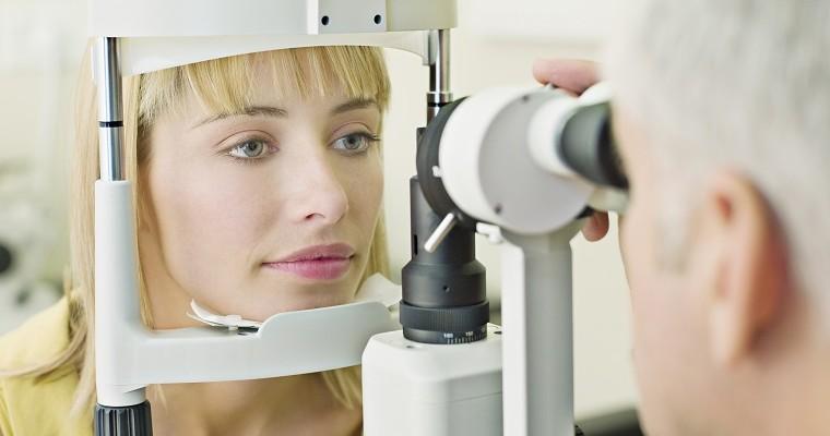  Lekarz okulista badający oczy młodej kobiety.