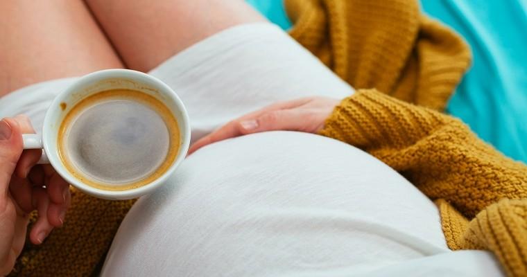 kobieta w ciąży z kubkiem kawy 