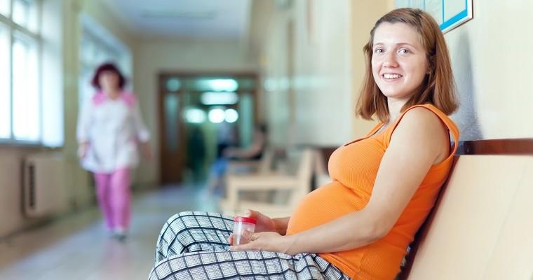Kobieta w ciąży, która robi badanie moczu 