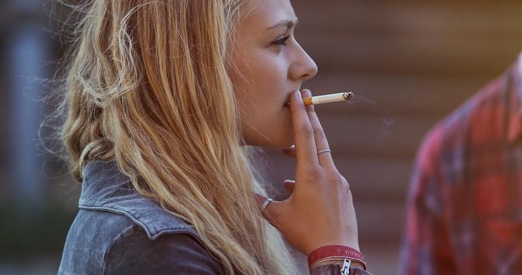 Młoda dziewczyna, która pali papierosa 