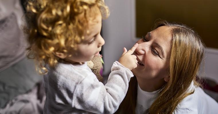 Mała dziewczynka dotyka nosa mamy 