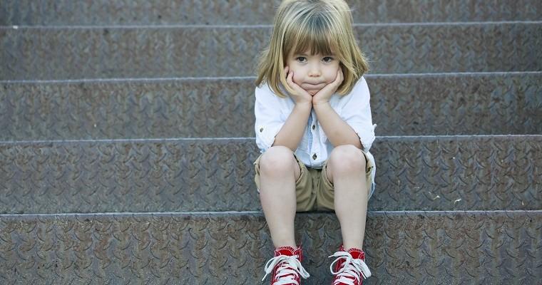 Dziecko, które siedzi na schodach 