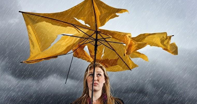 Fot: Kobieta, która stoi pod zepsutą parasolką 