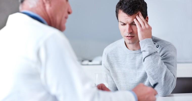 Mężczyzna z bolącą głową, podczas wizyty u lekarza