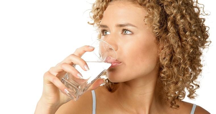 Kobieta pije wodę ze szklanki